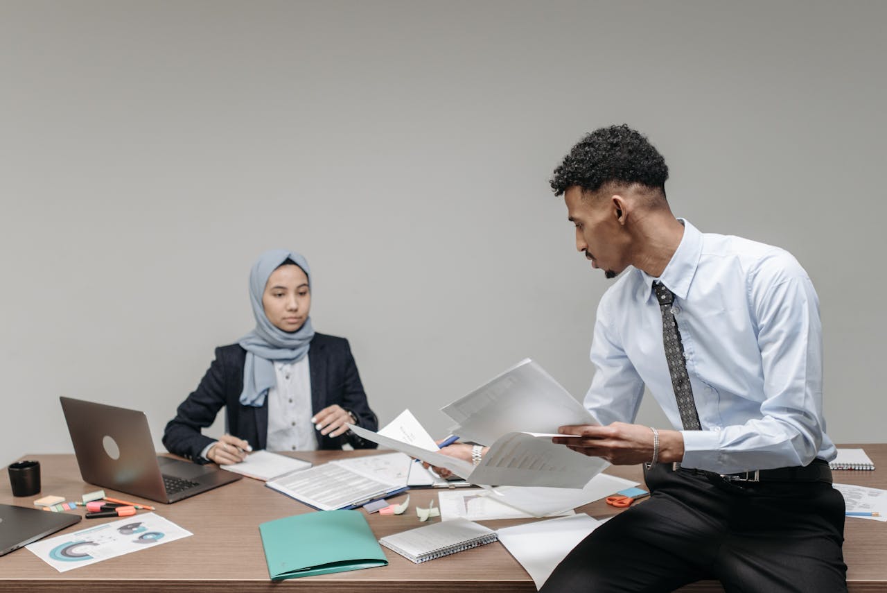 Muslim business professionals collaborating at desk in modern office.